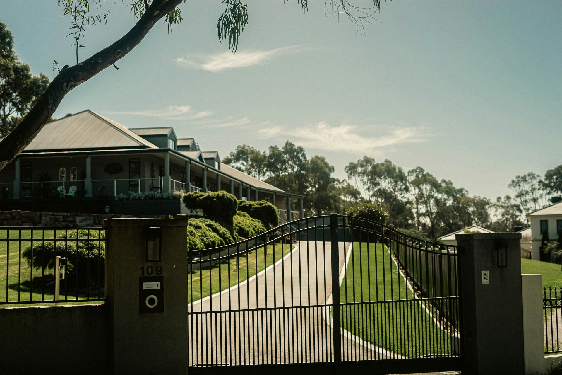 a gated driveway with a house in the background