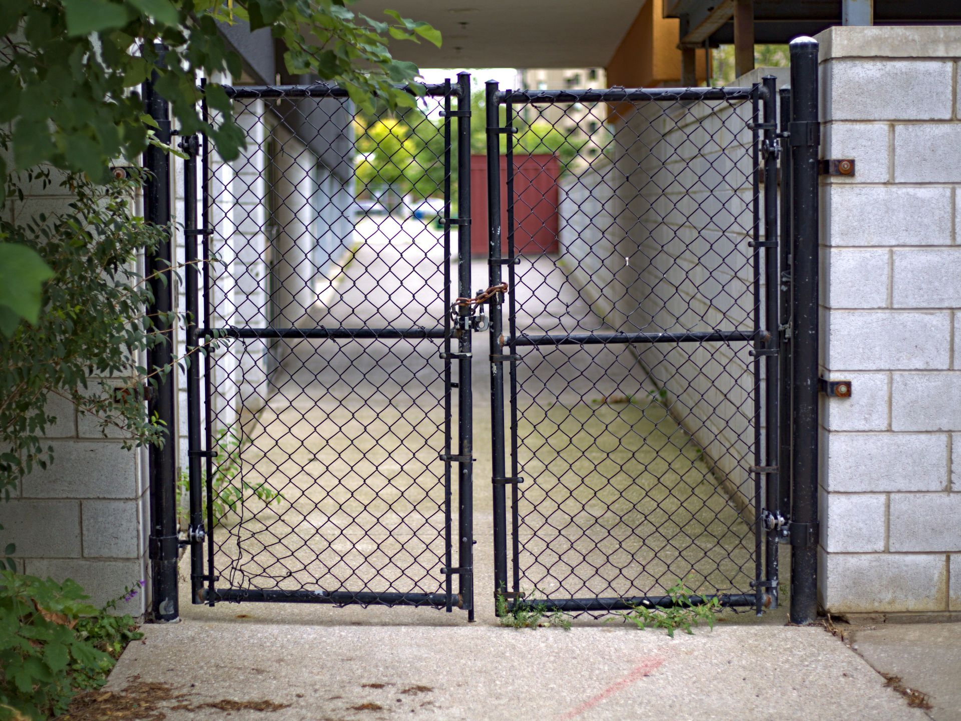 A locked chain link gate in an urban alleyway in Toronto, Canada.